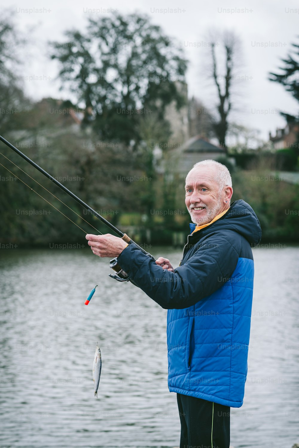 a man standing on a dock while holding a fish