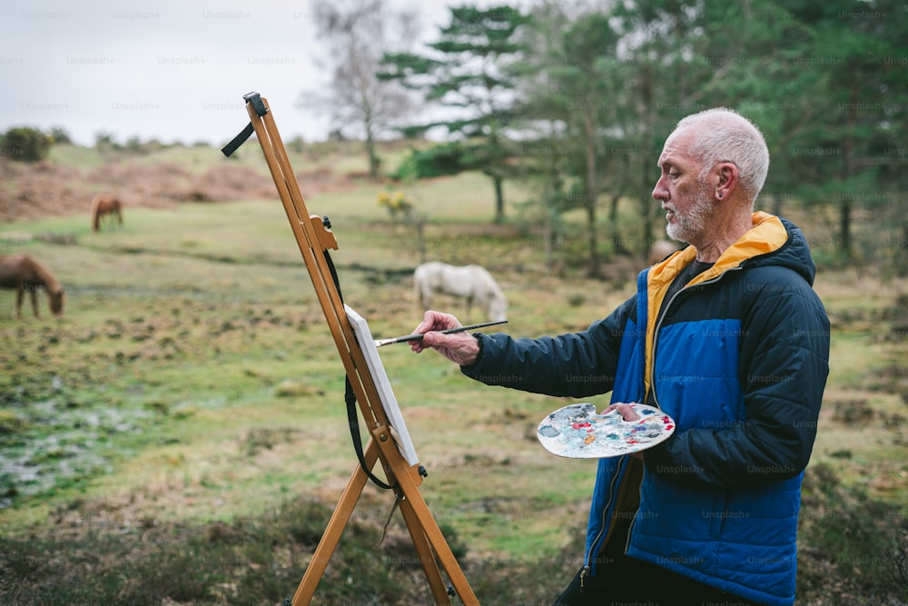 a man is painting horses in a field