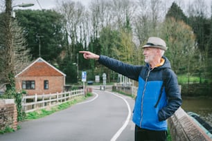 a man pointing at something on the side of a road
