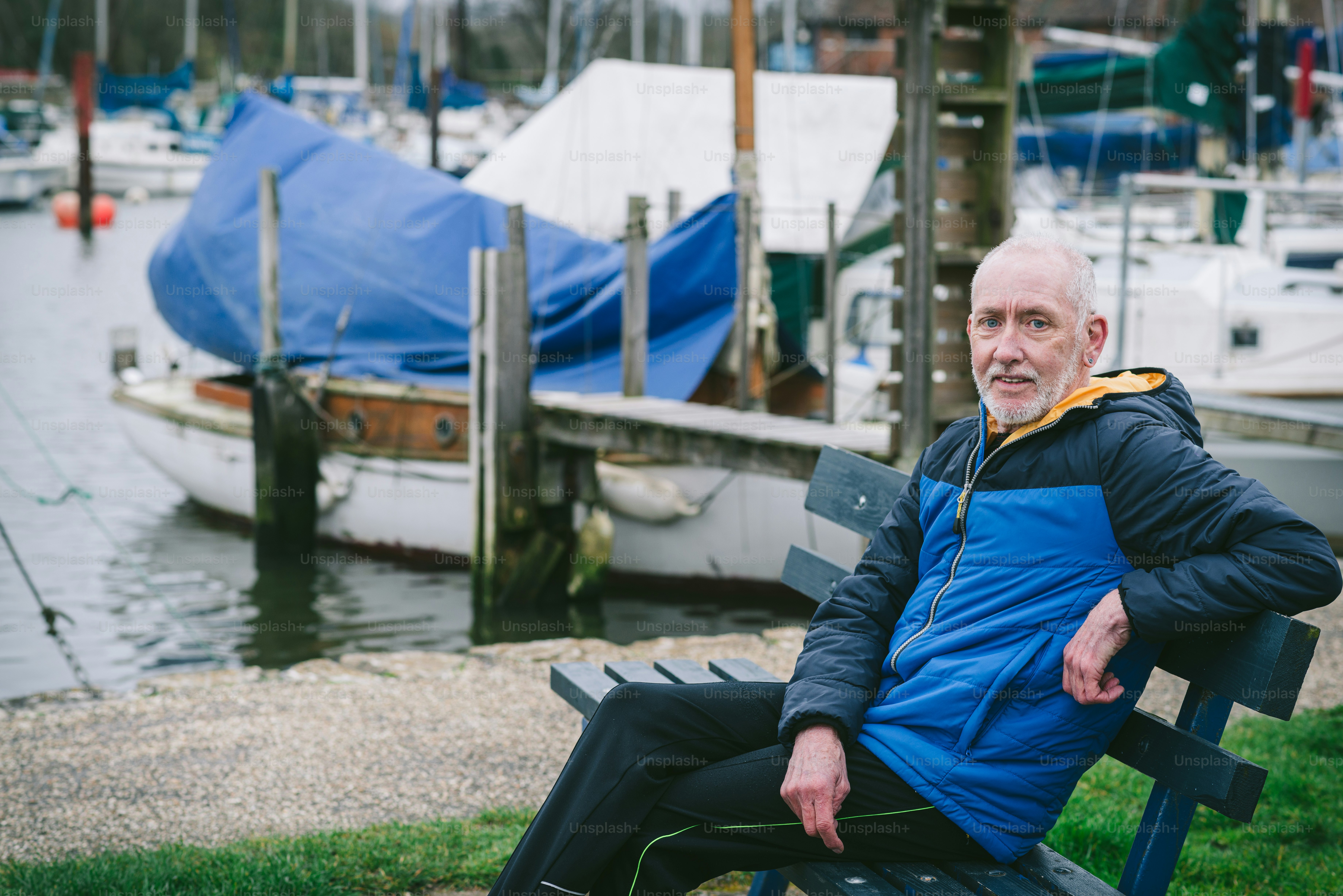 A man sitting on a blue bench in a park photo – Man Image on Unsplash