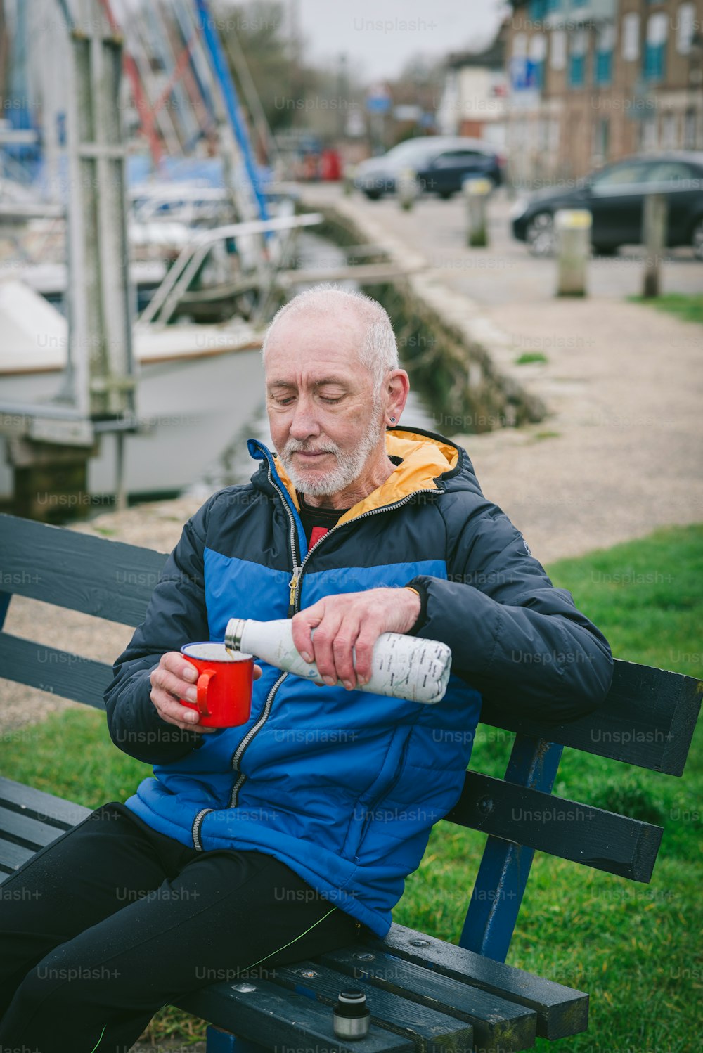 Un homme assis sur un banc avec une tasse de café