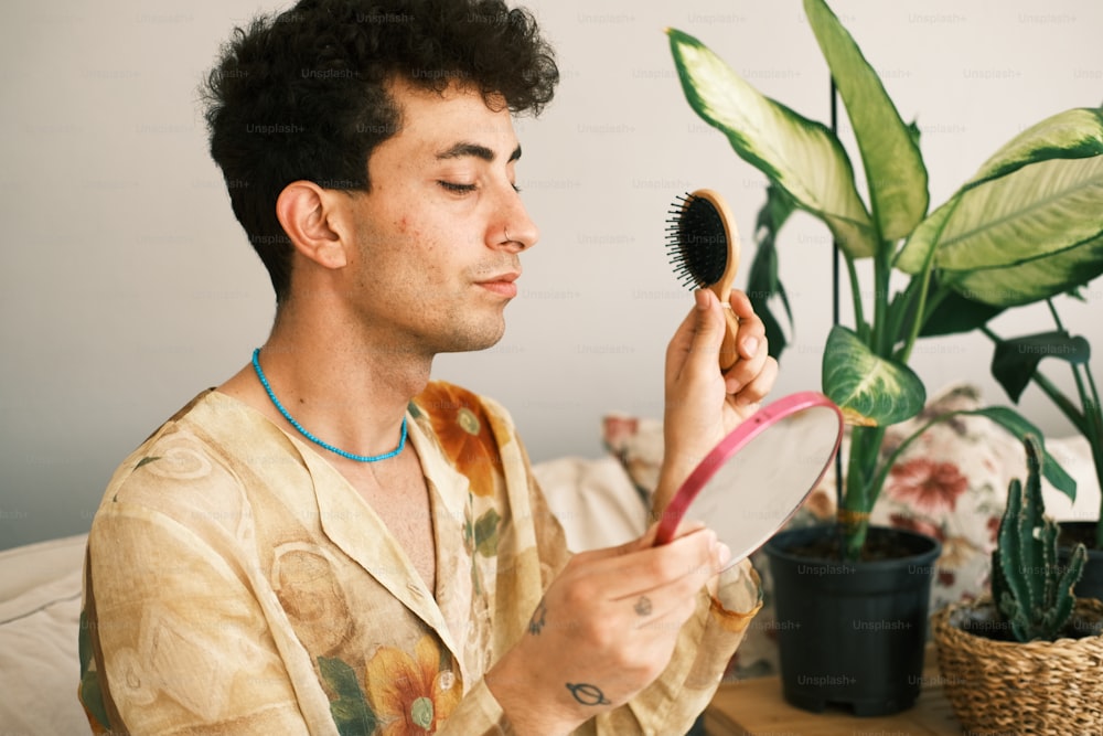 a man is blow drying his hair with a brush