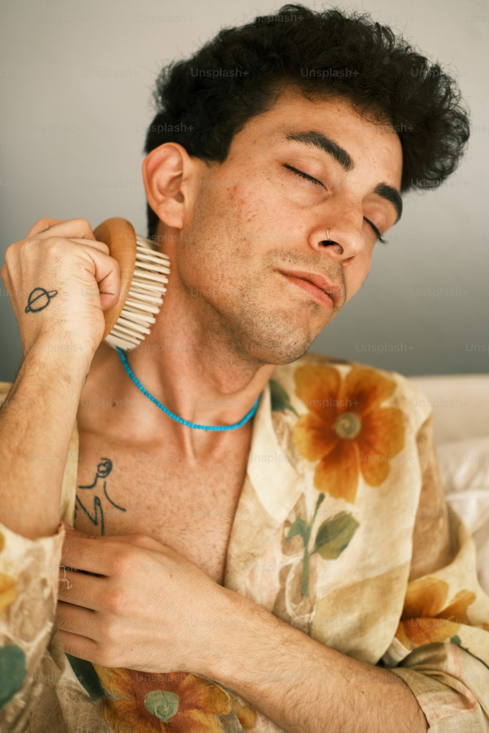 a man with his eyes closed holding a hair brush