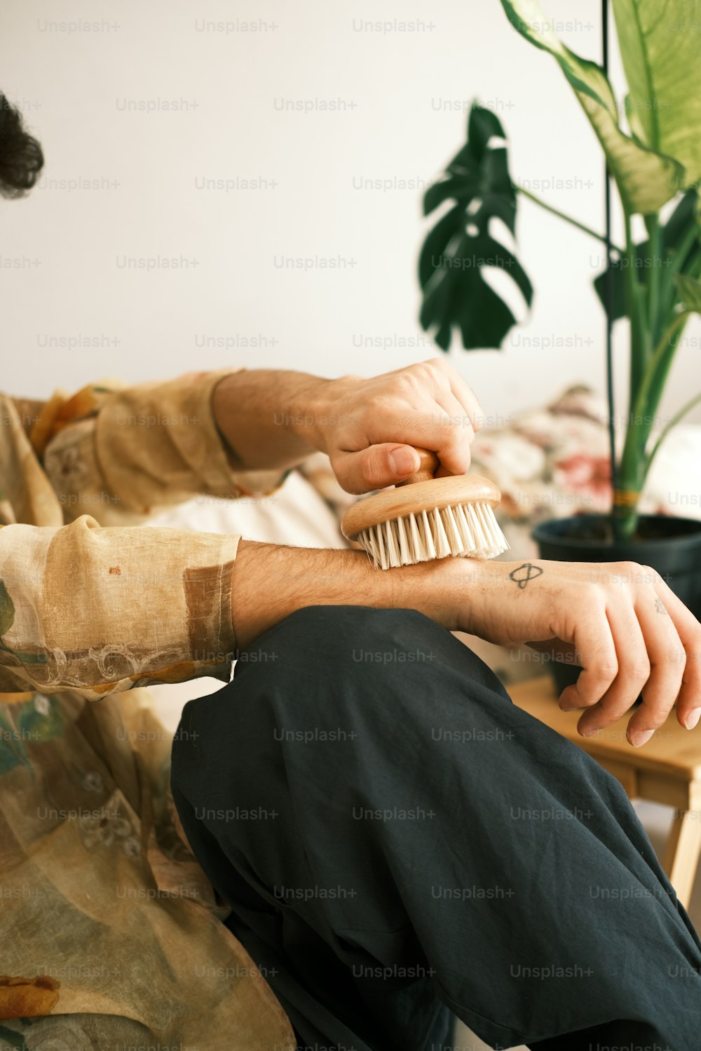 Un hombre sentado en un sofá con un cepillo en la mano