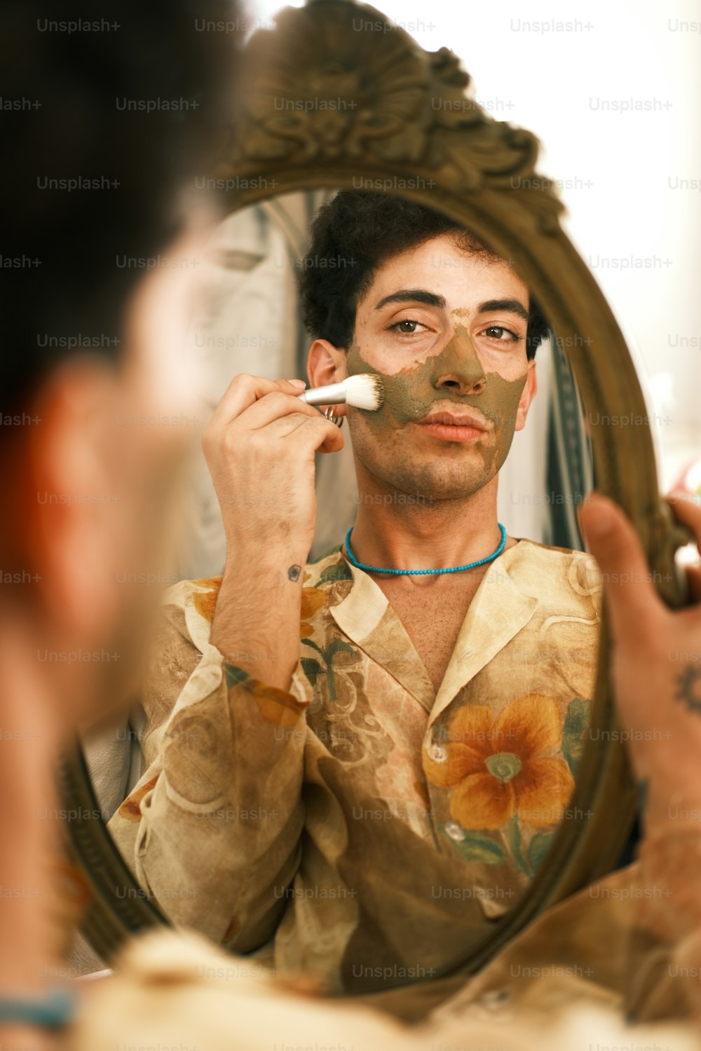 Un hombre afeitándose la cara frente a un espejo