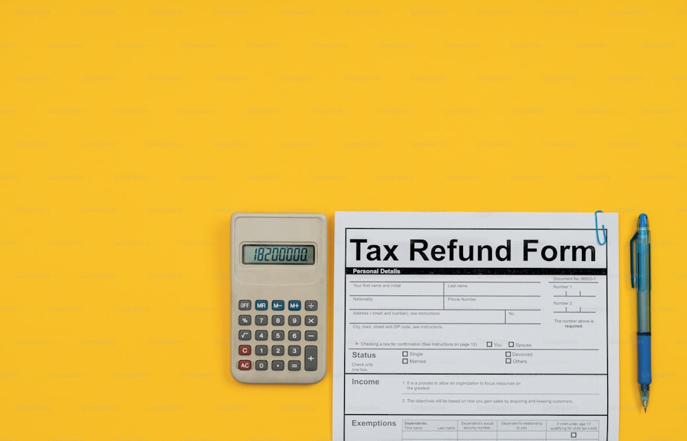 a tax refund form next to a calculator and a pen