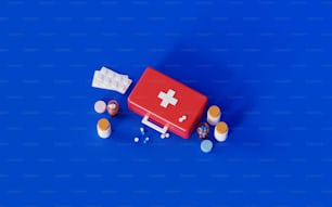 Un kit di pronto soccorso rosso seduto sopra una superficie blu