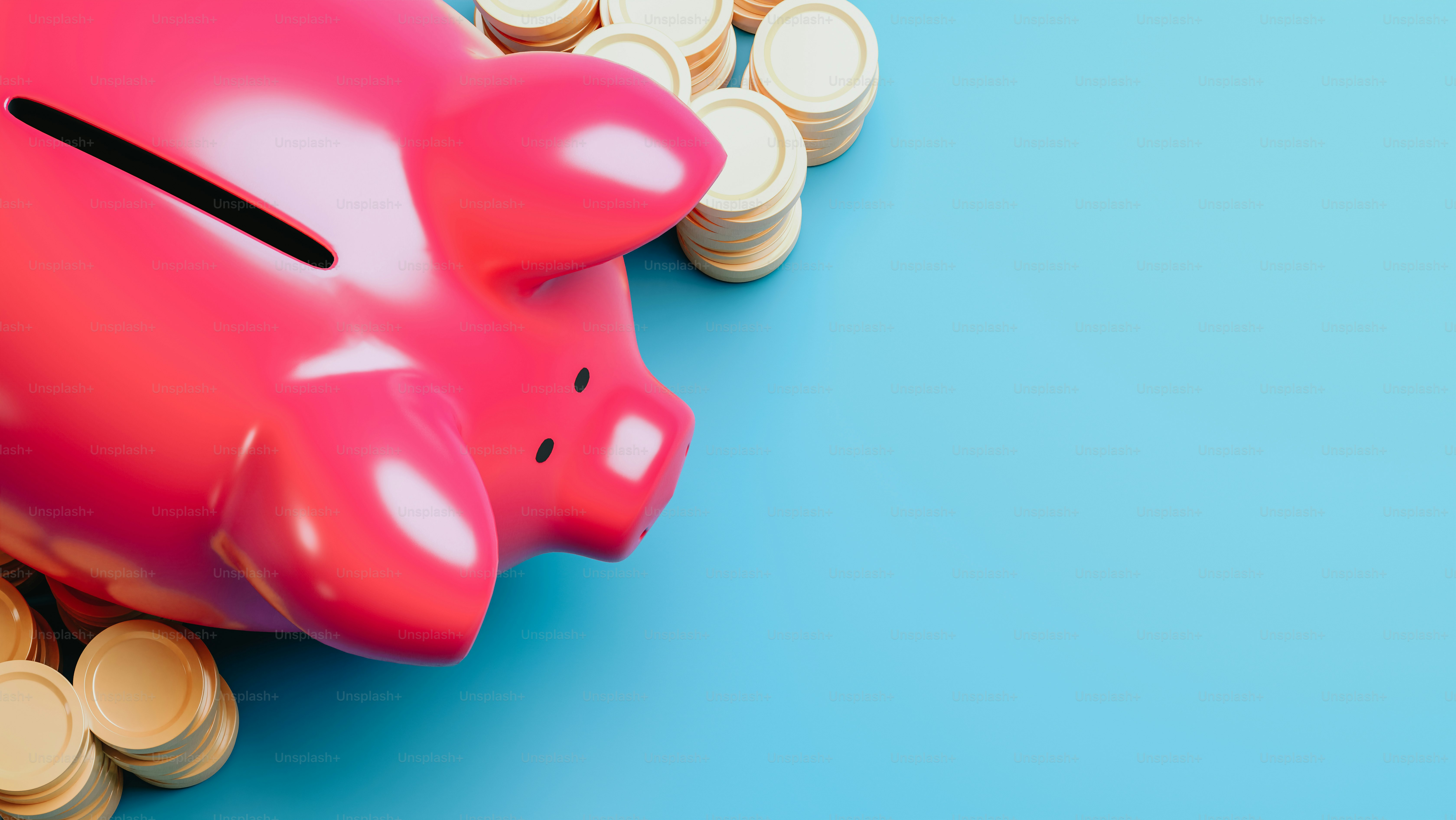 a pink piggy bank sitting on top of a pile of coins