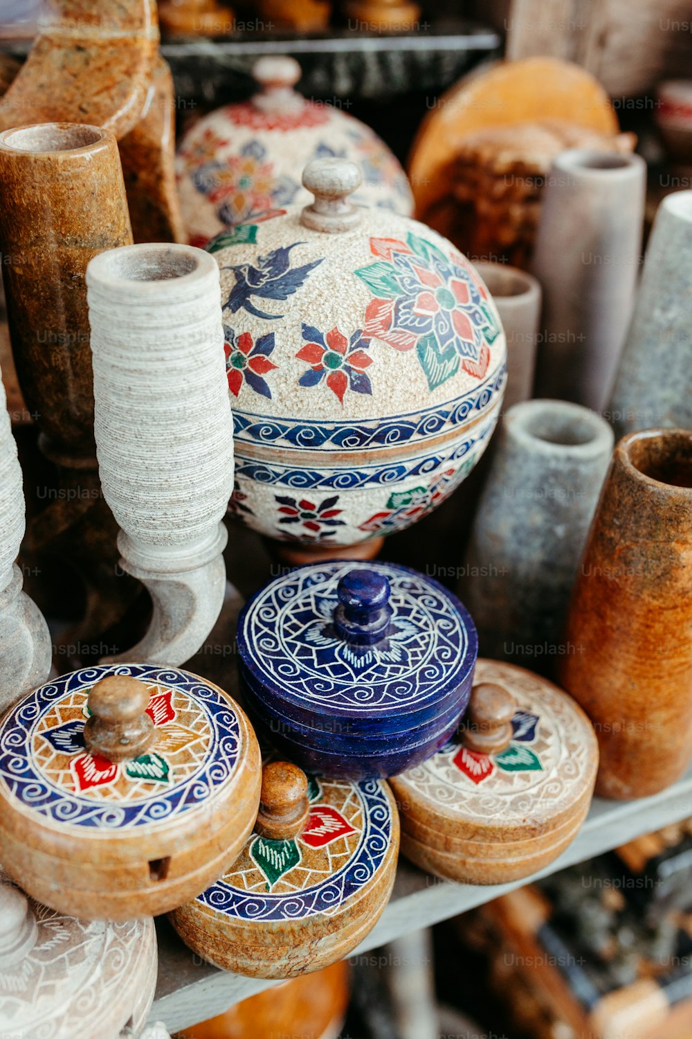 a bunch of vases that are sitting on a shelf
