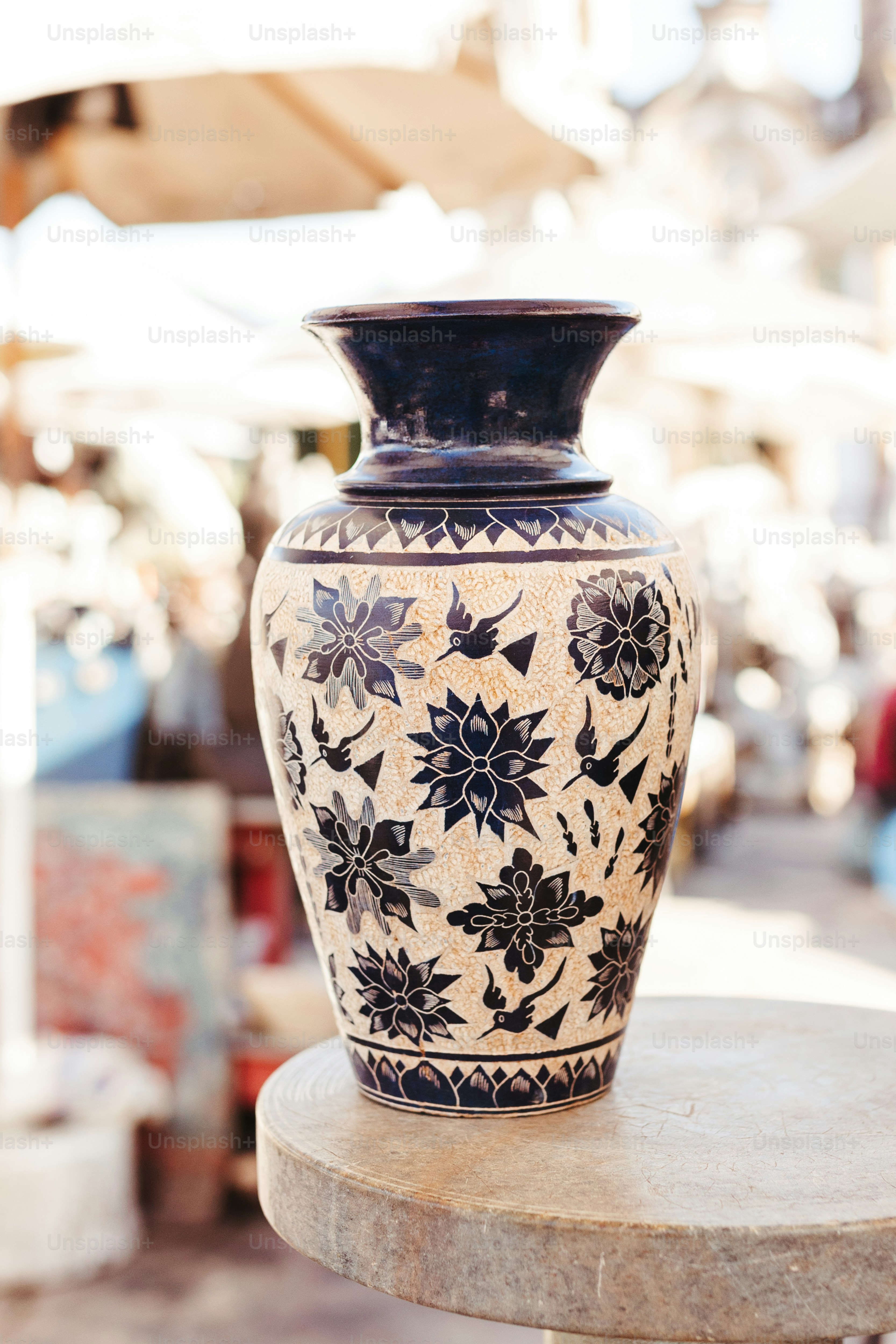 Un jarrón blanco y negro sentado encima de una mesa