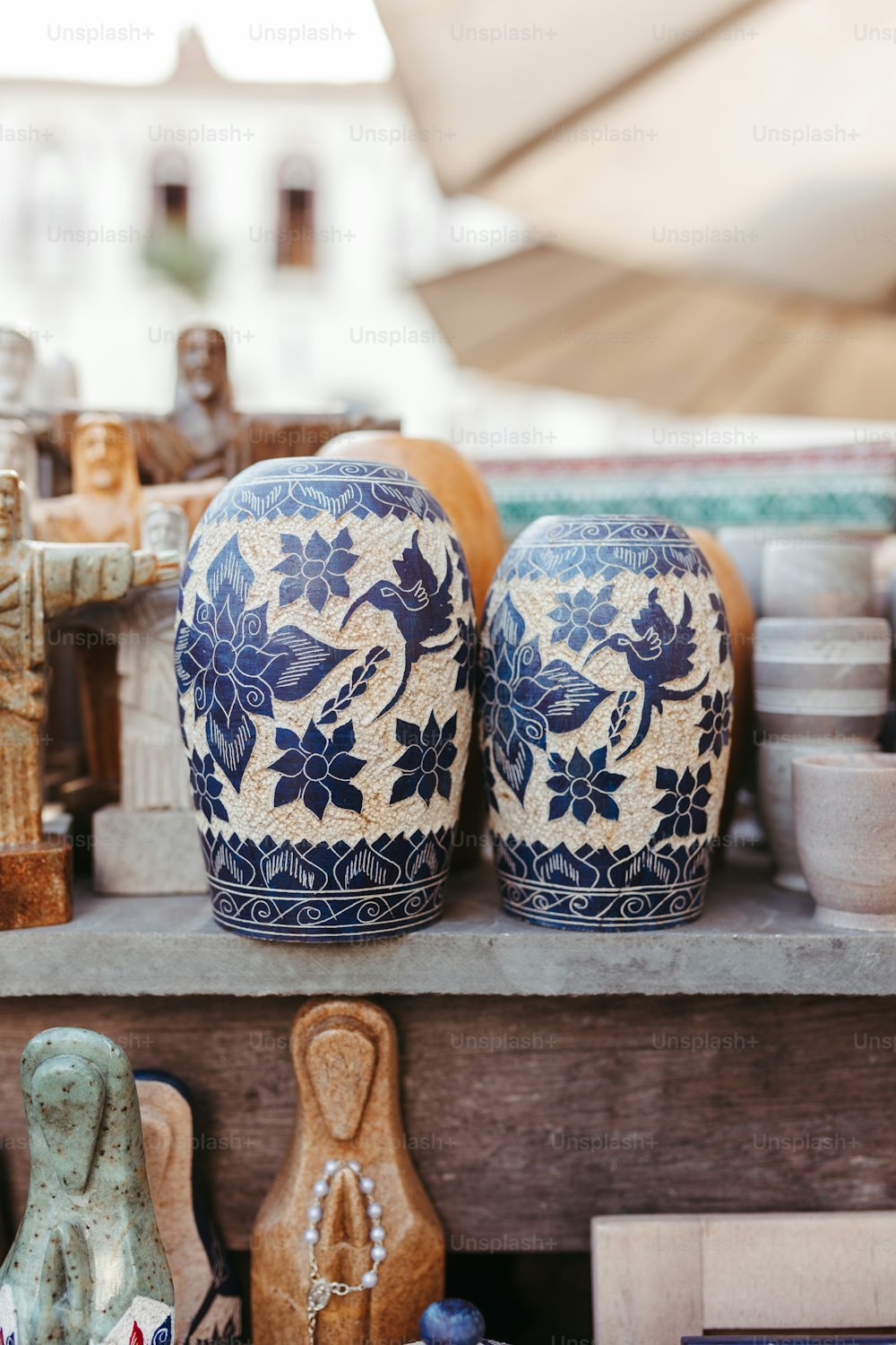 two blue and white vases sitting on a shelf