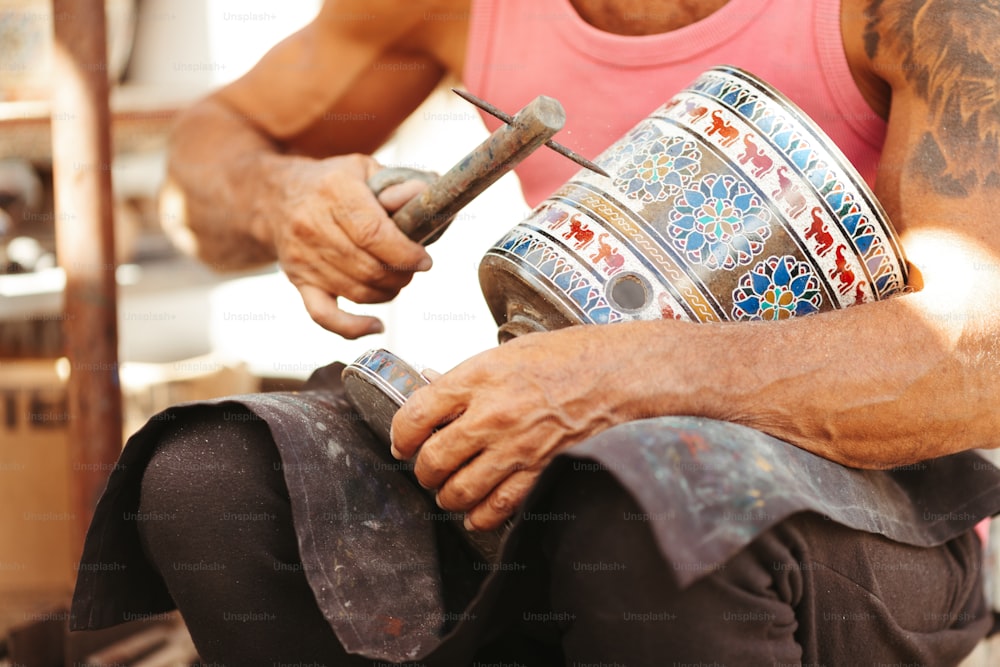 a man holding a hammer and a metal container