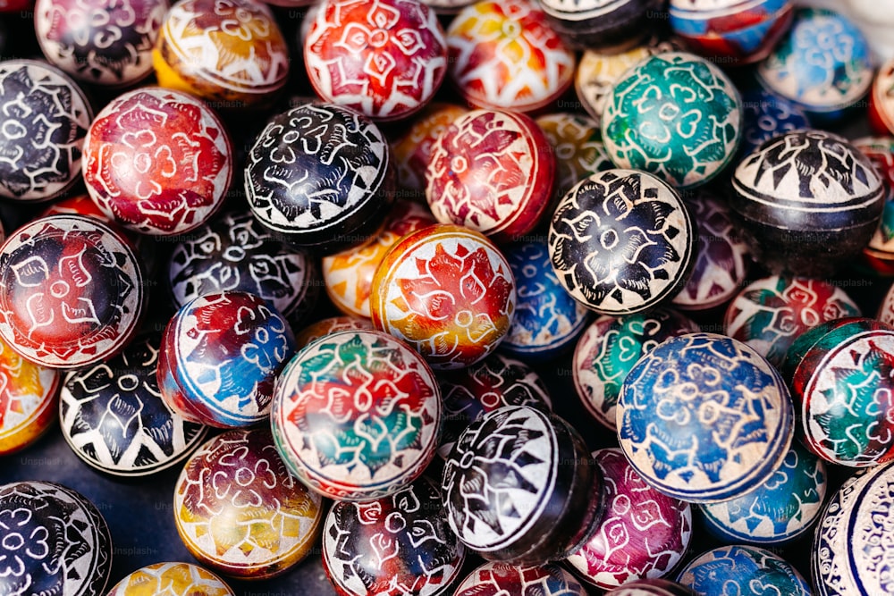 a pile of colorful painted eggs sitting on top of each other