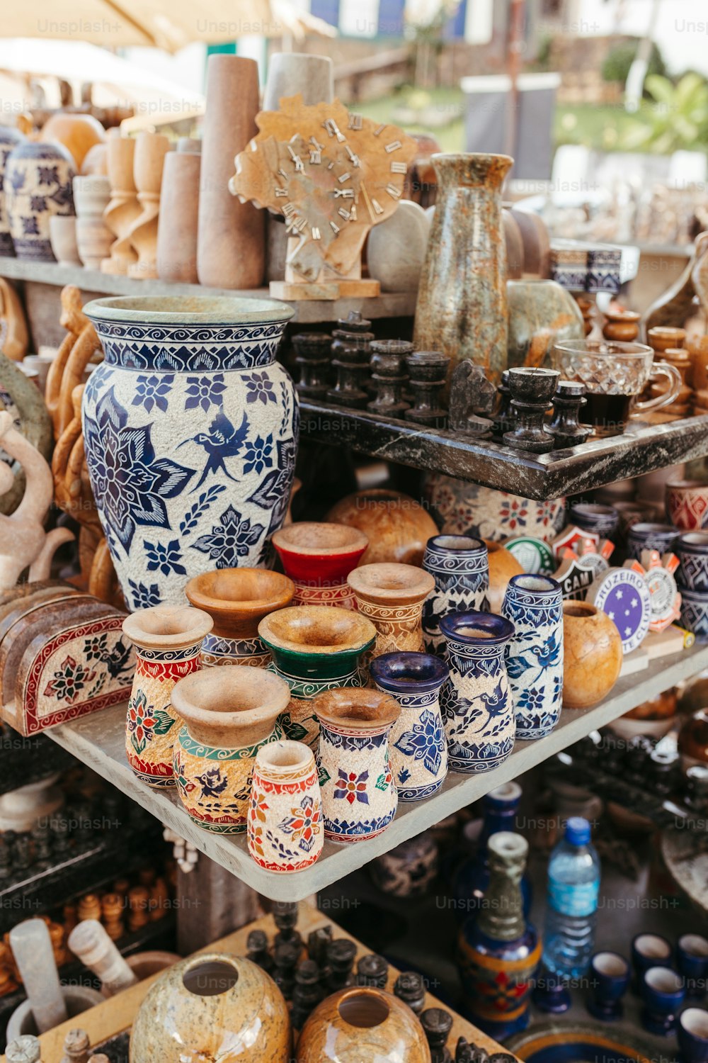 a shelf filled with lots of pottery and vases