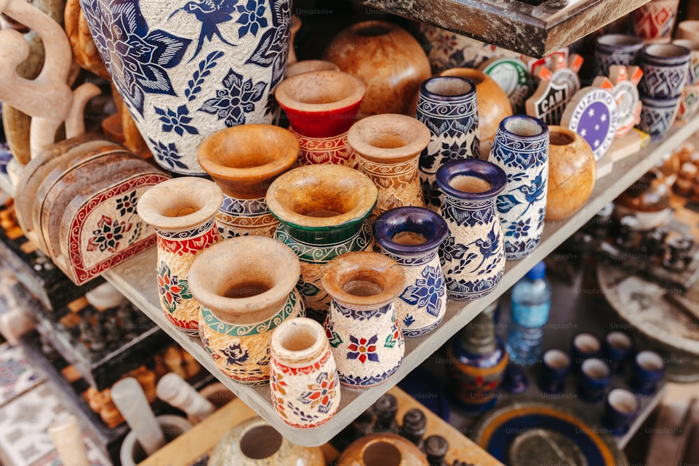 a bunch of vases that are on a shelf