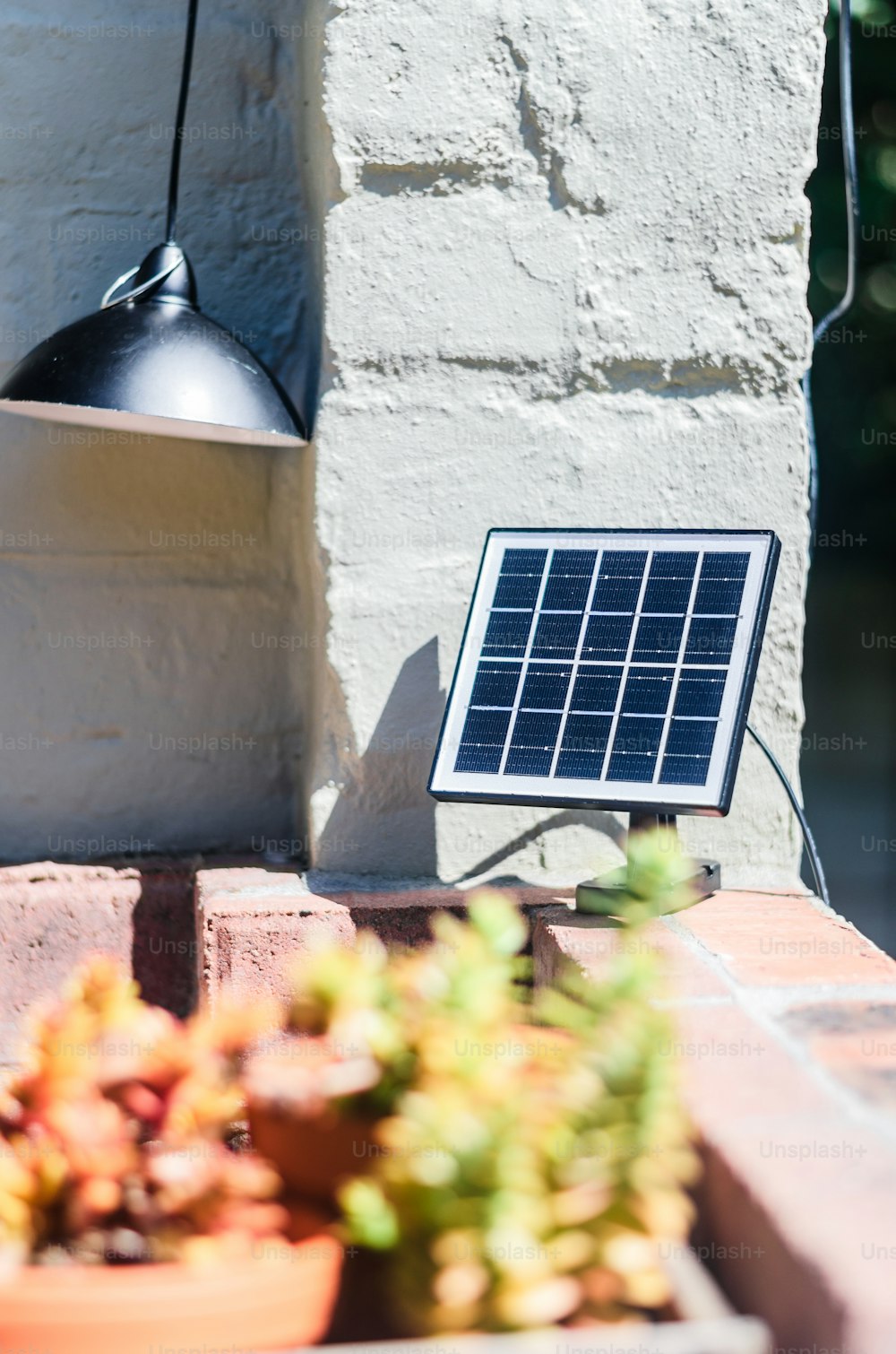 Un pequeño panel solar sentado encima de una pared de ladrillo