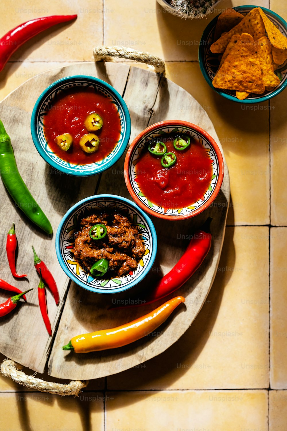 a plate of food with chili, peppers, and other condiments