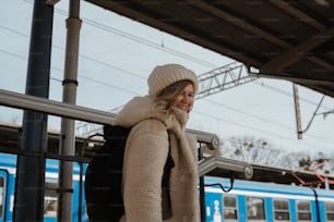 a woman in a hat and coat is on the phone
