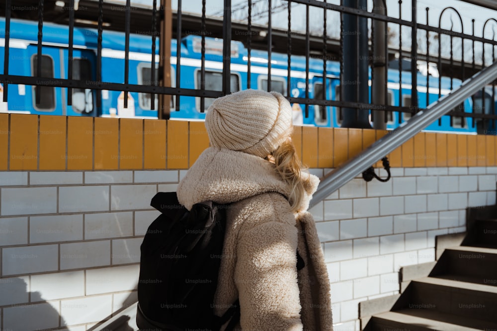 a woman with a backpack is walking up some stairs