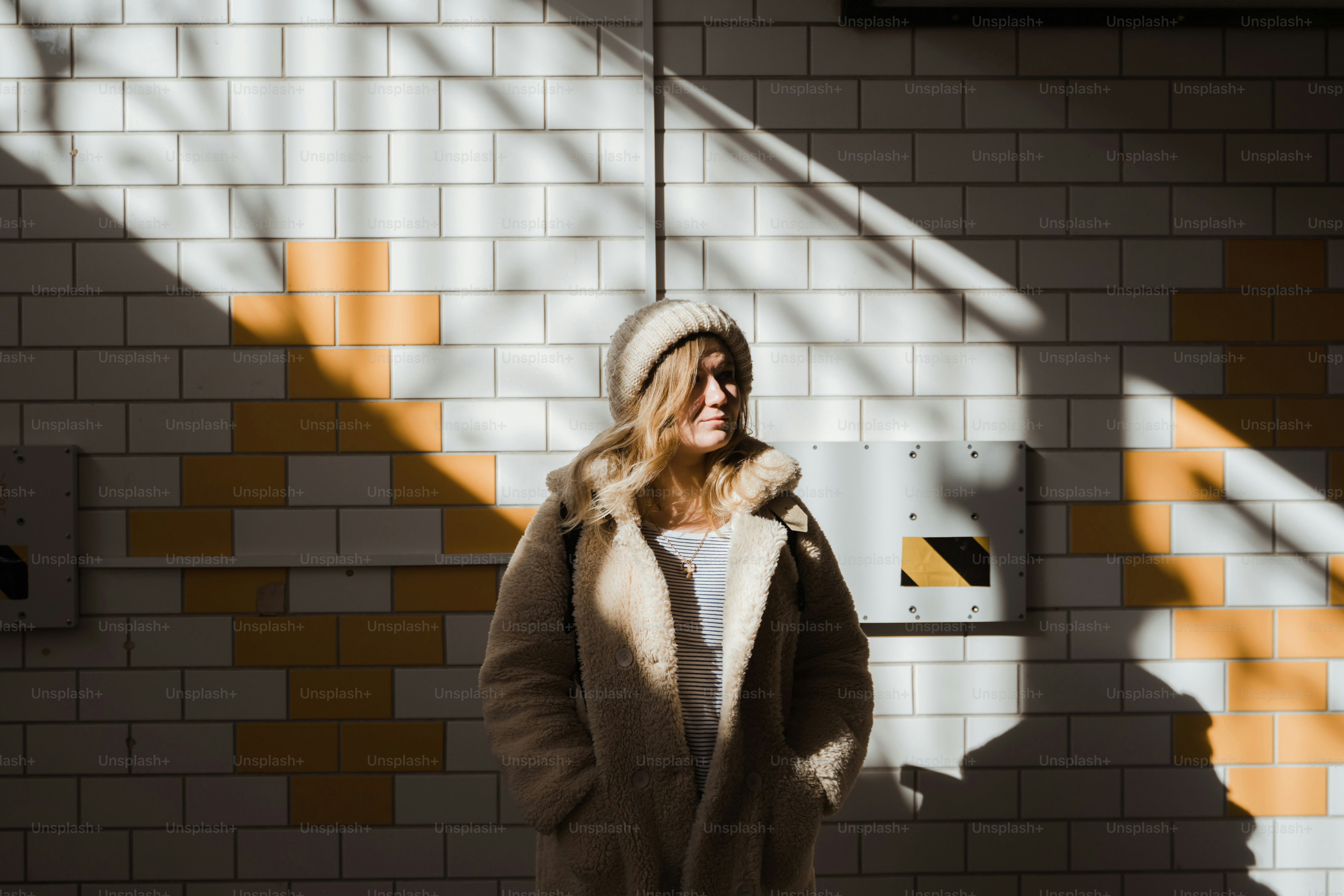 a woman standing in front of a brick wall