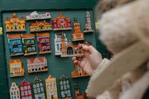 a person is holding a small toy in front of a wall of buildings