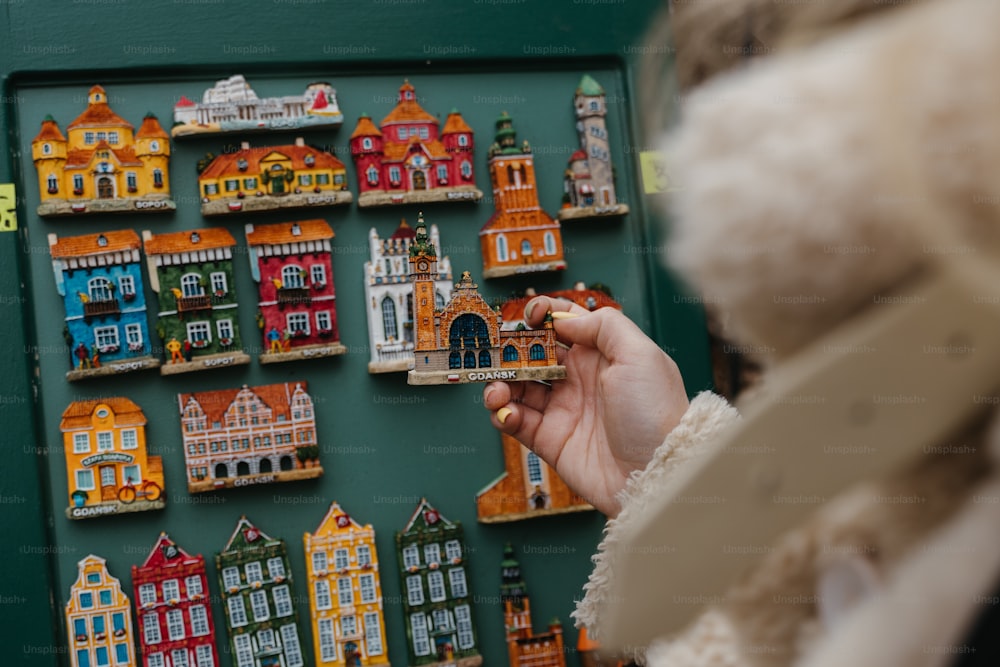 a person is holding a small toy in front of a wall of buildings