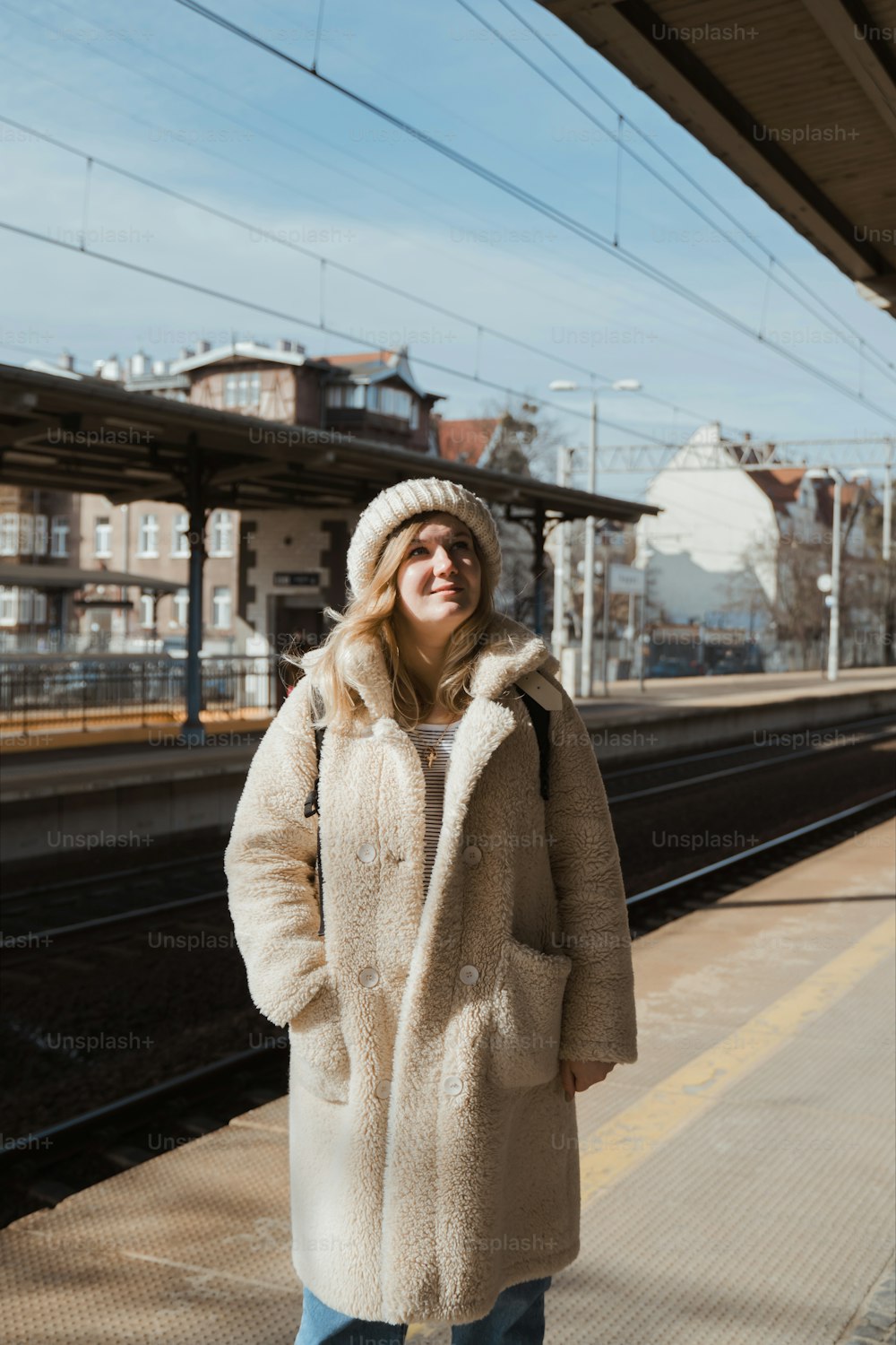 a woman is standing on a train platform