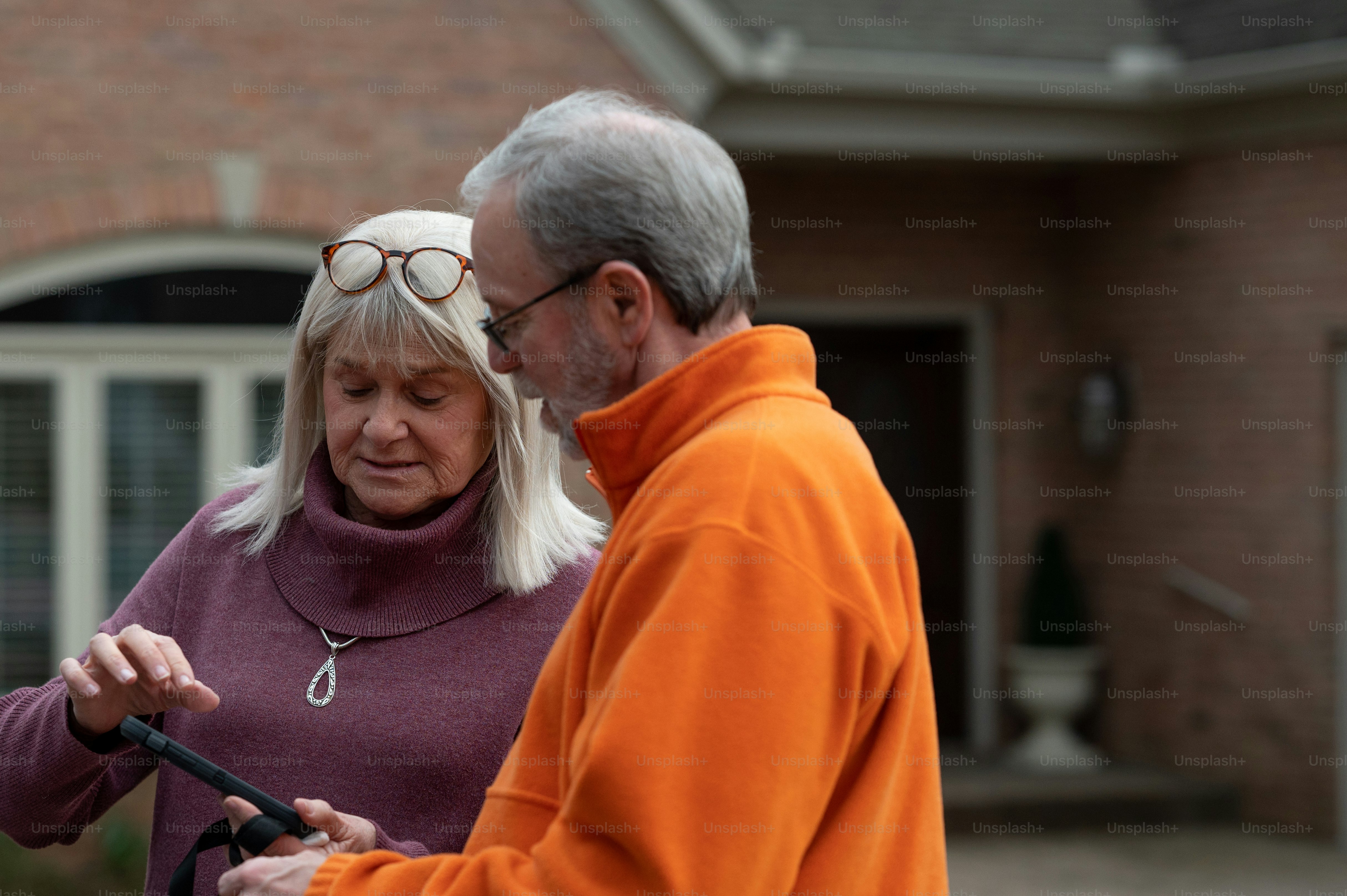 a man and a woman standing in front of a house