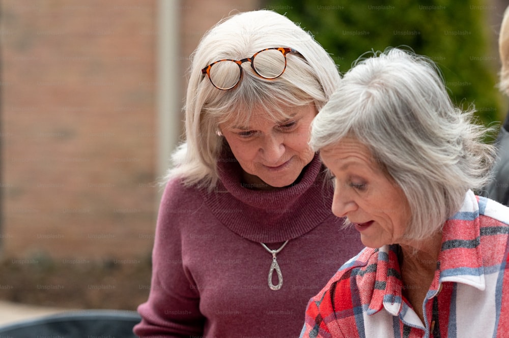 Zwei ältere Frauen schauen auf ein Handy