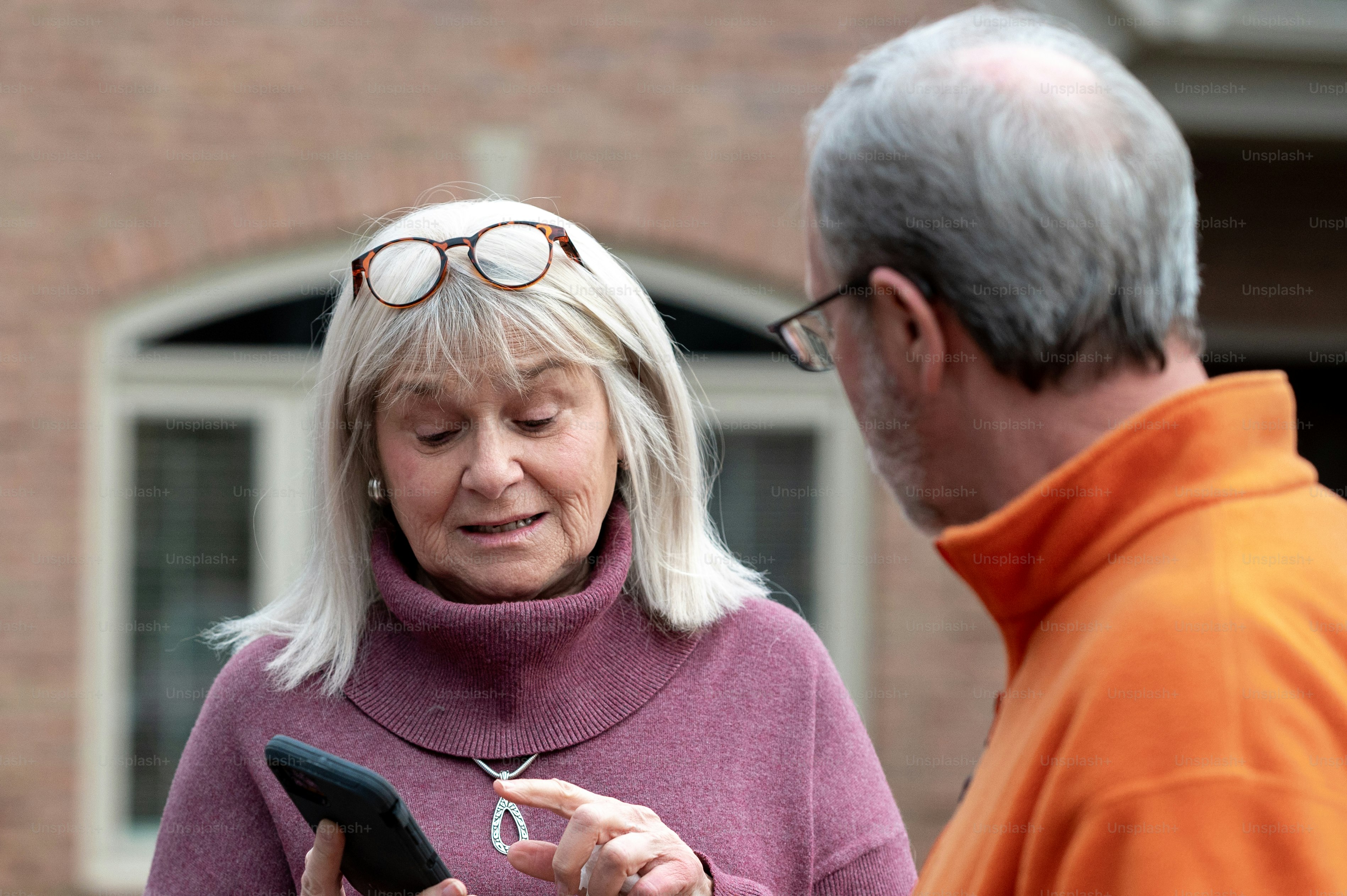 a man and a woman looking at a cell phone