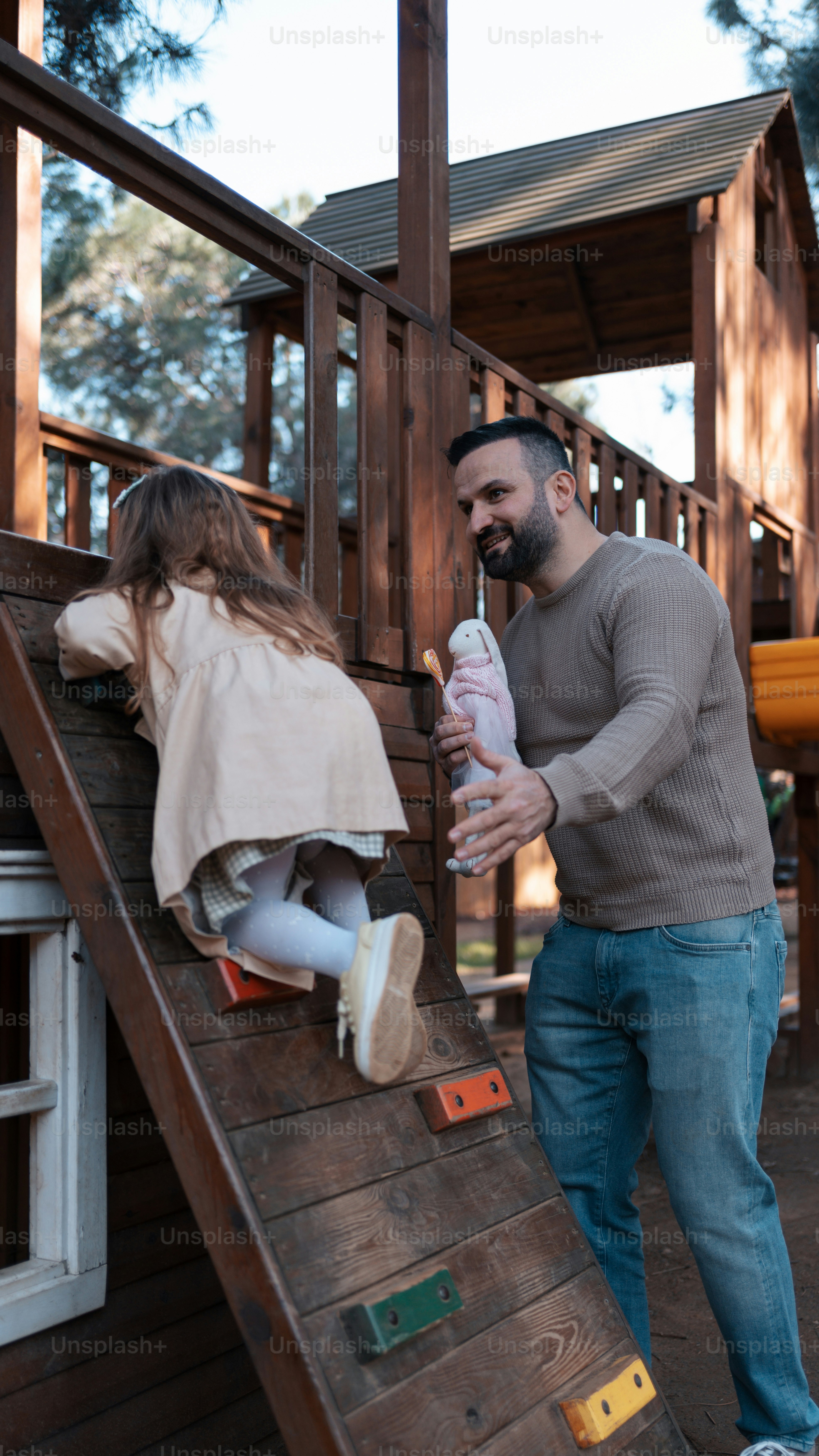 a man and a little girl playing on a slide