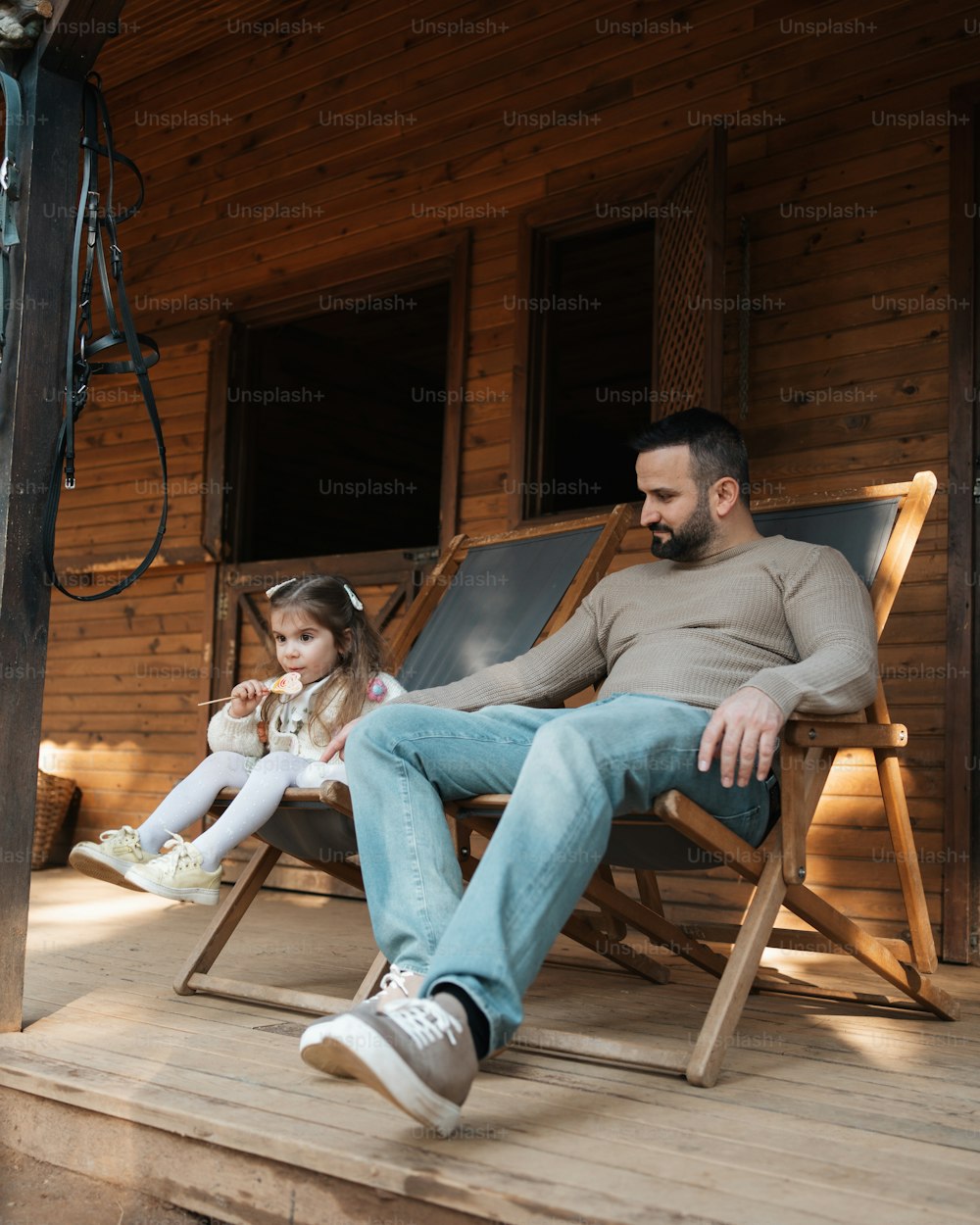 Un uomo e una bambina seduti su un portico