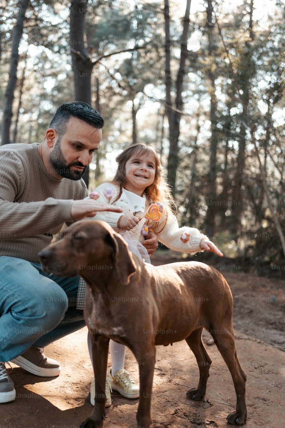 Un homme et une petite fille assis sur un banc avec un chien