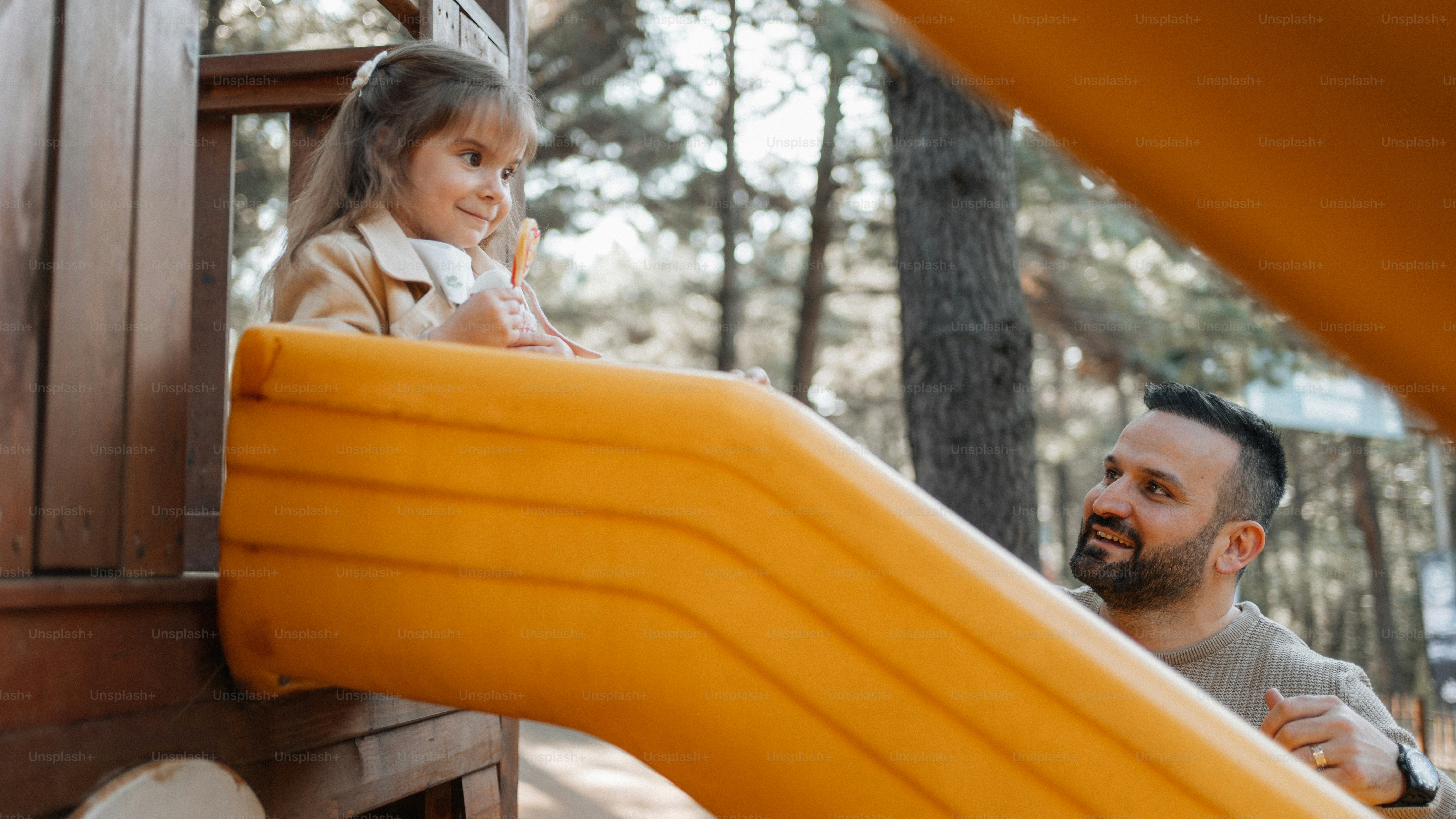 滑り台で遊ぶ男と少女
