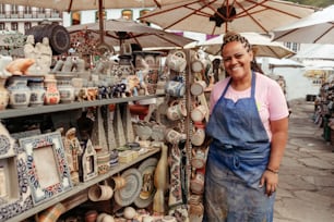 a woman standing in front of a display of pottery