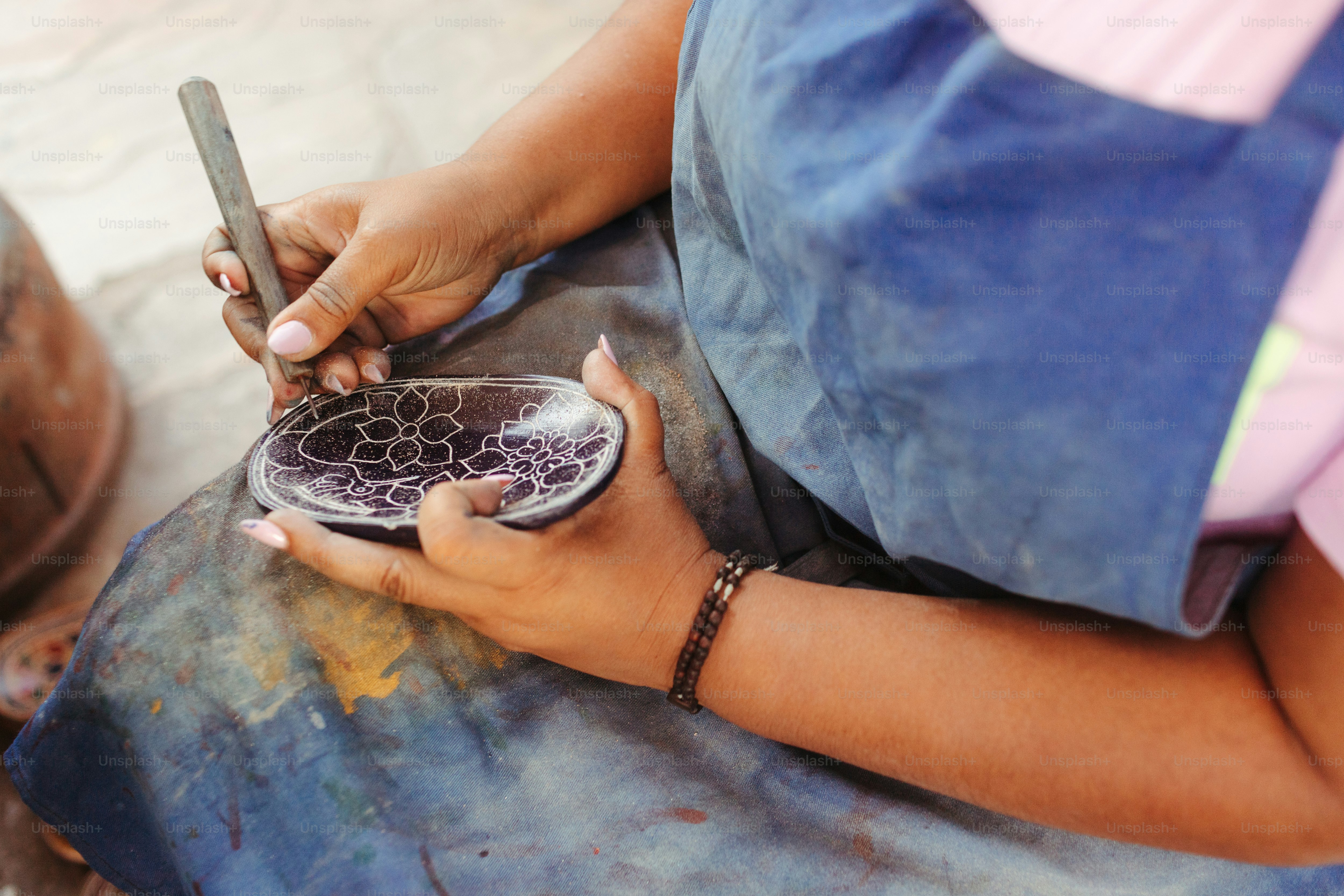 a woman using a cell phone while sitting on a stool