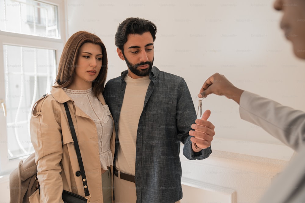 a man and a woman looking at a house key