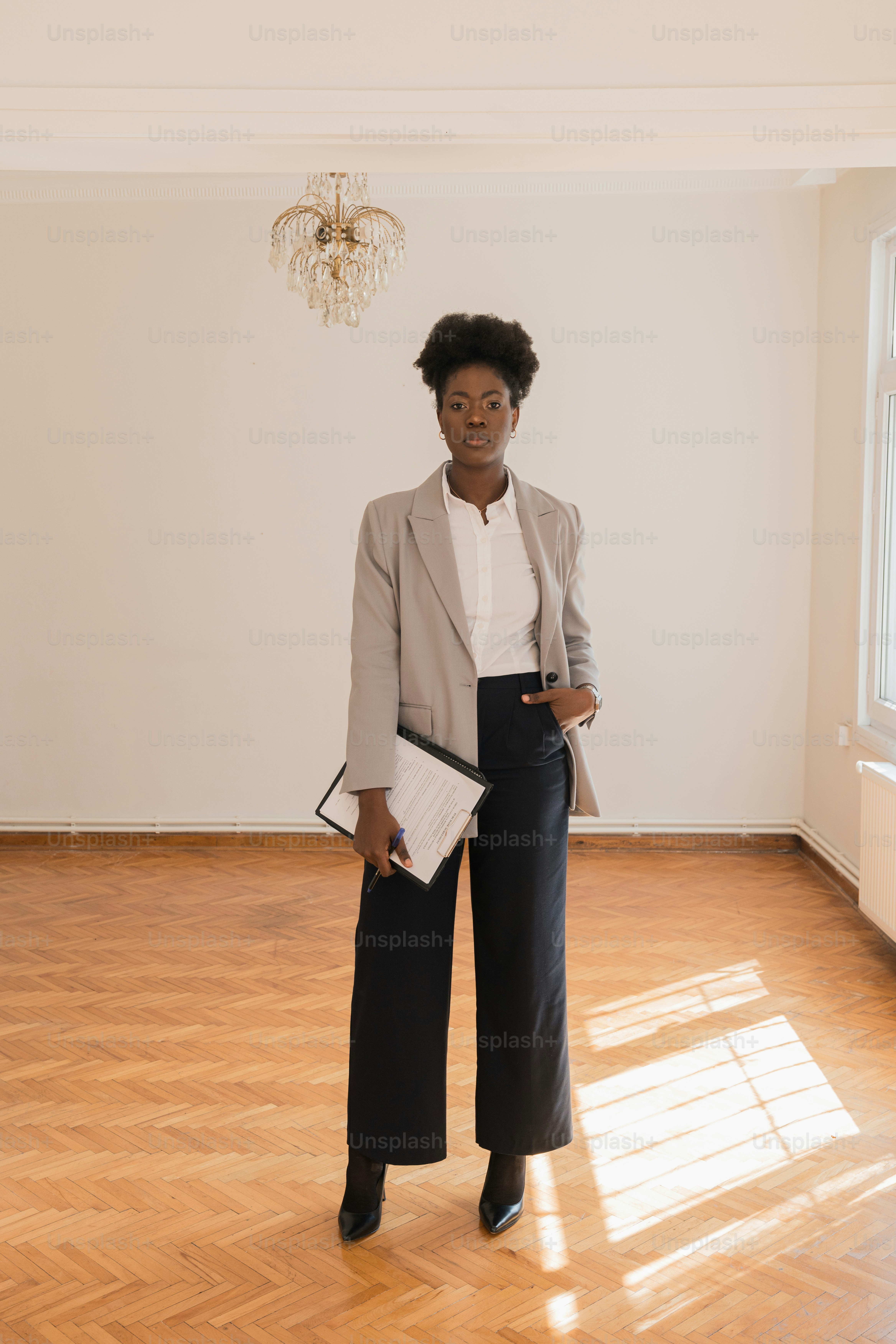 a woman standing in a room holding a folder