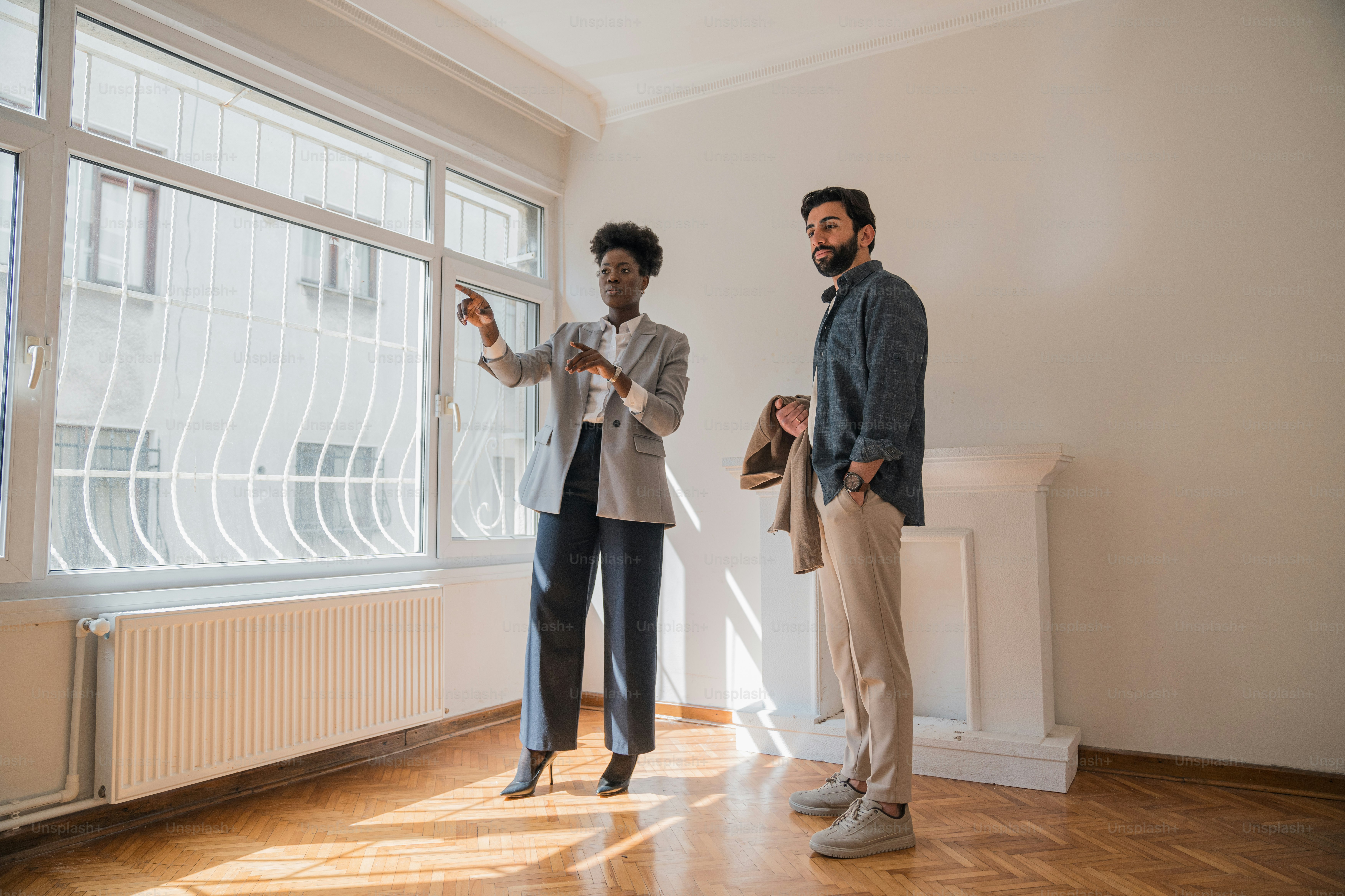 a man and a woman standing in front of a window