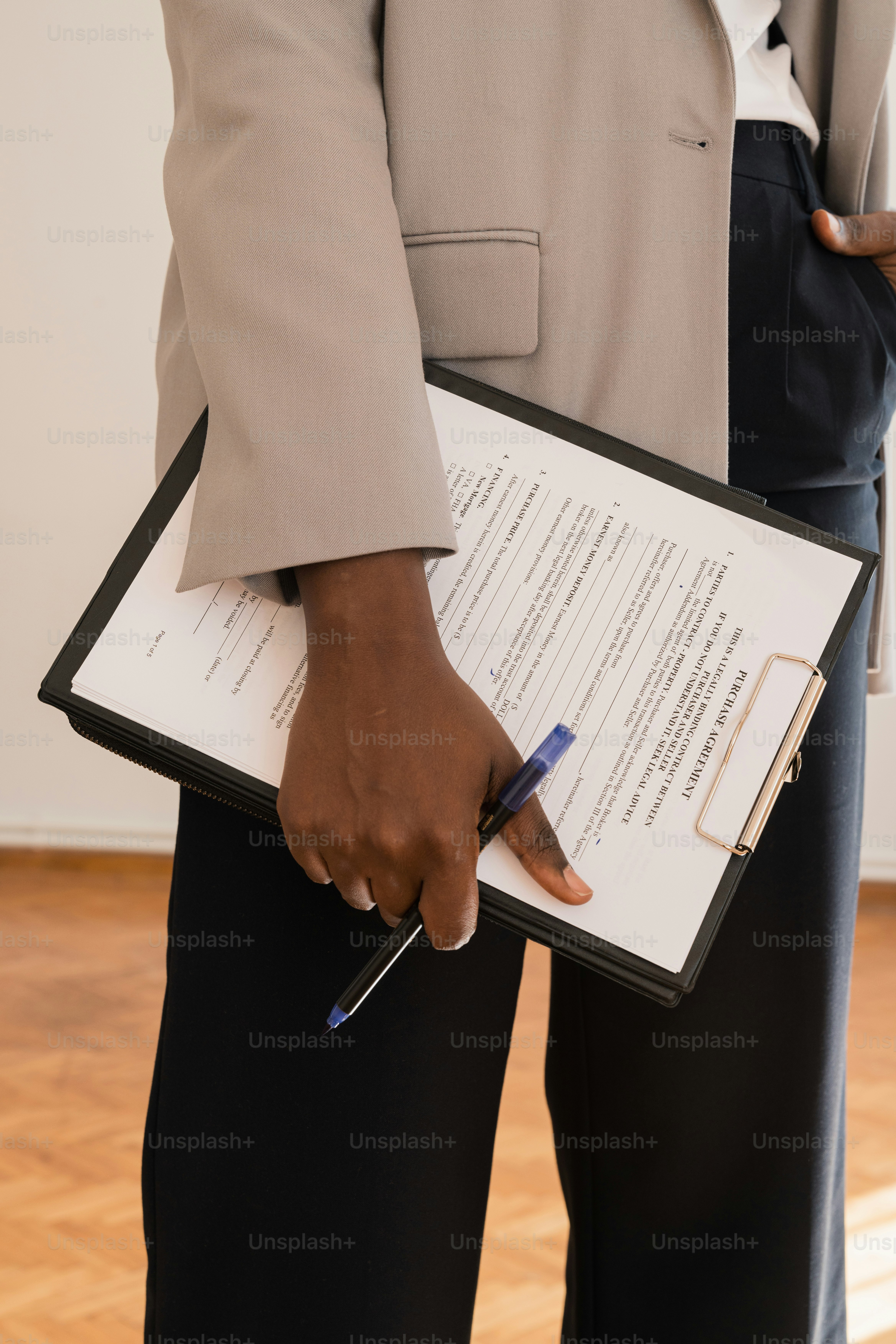 a person holding a clipboard with a pen in their hand
