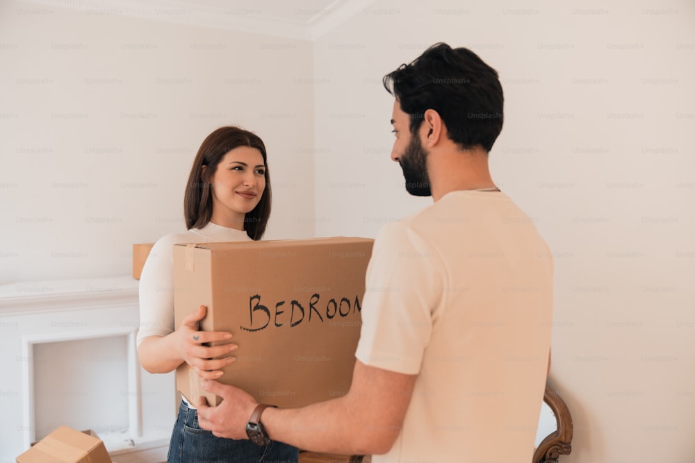 a man and a woman holding a cardboard box