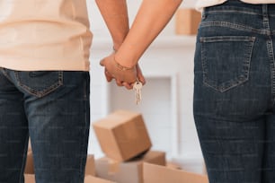 a couple holding hands while standing next to boxes