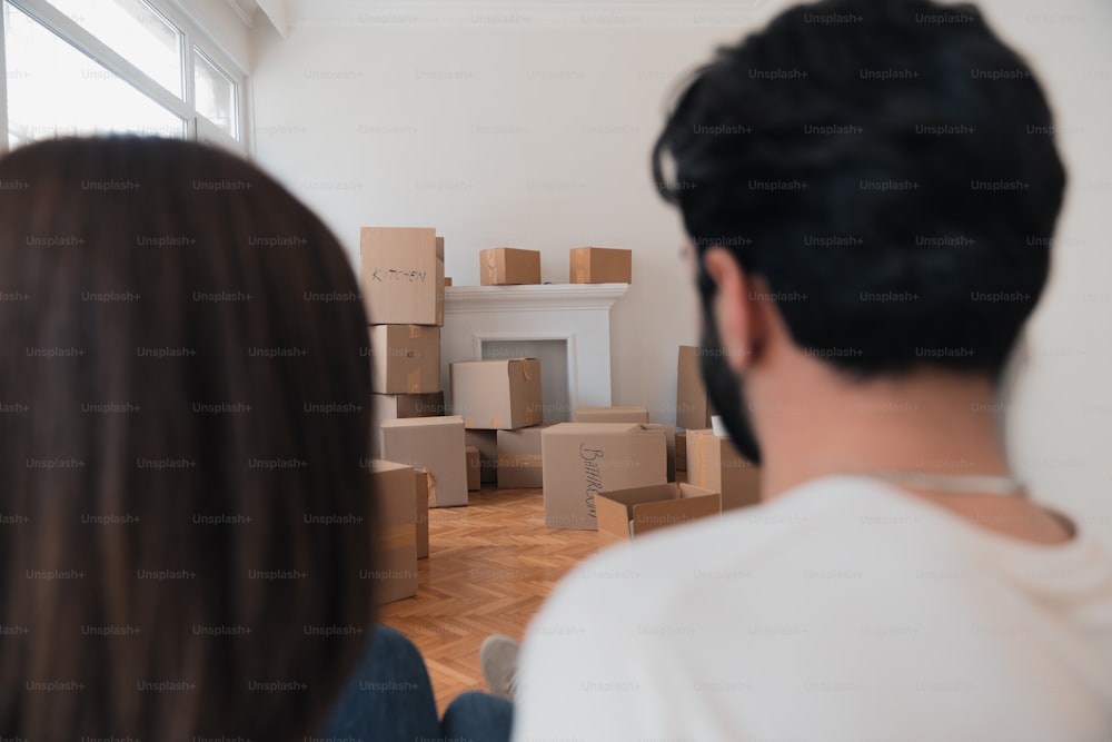 a man and a woman looking at boxes in a room