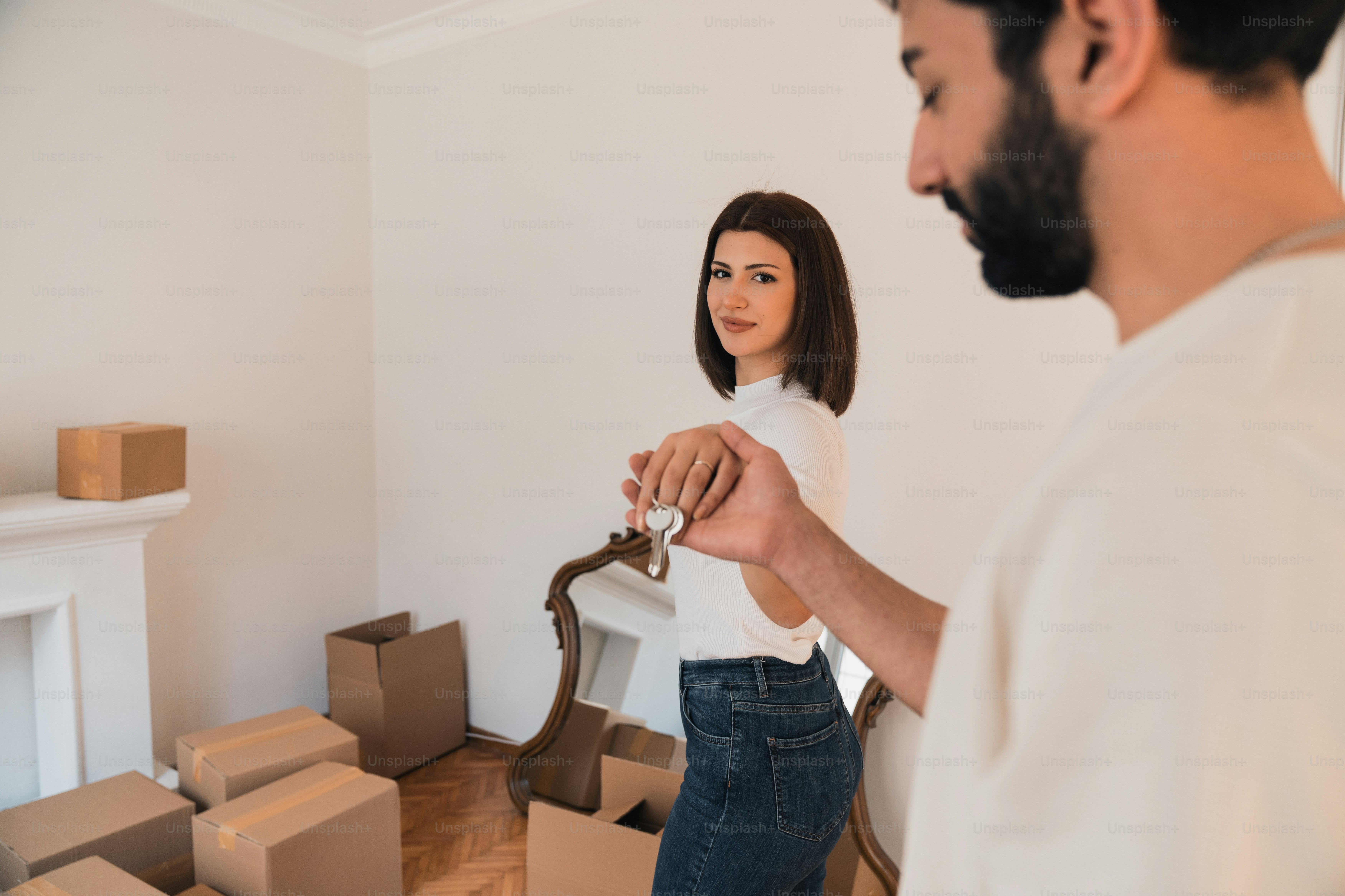 a man and a woman standing in a room with moving boxes