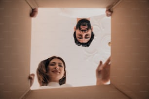 a man and a woman looking at each other through a box