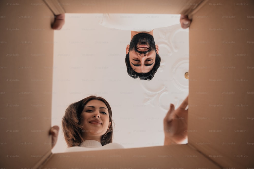 Un hombre y una mujer mirándose a través de una caja