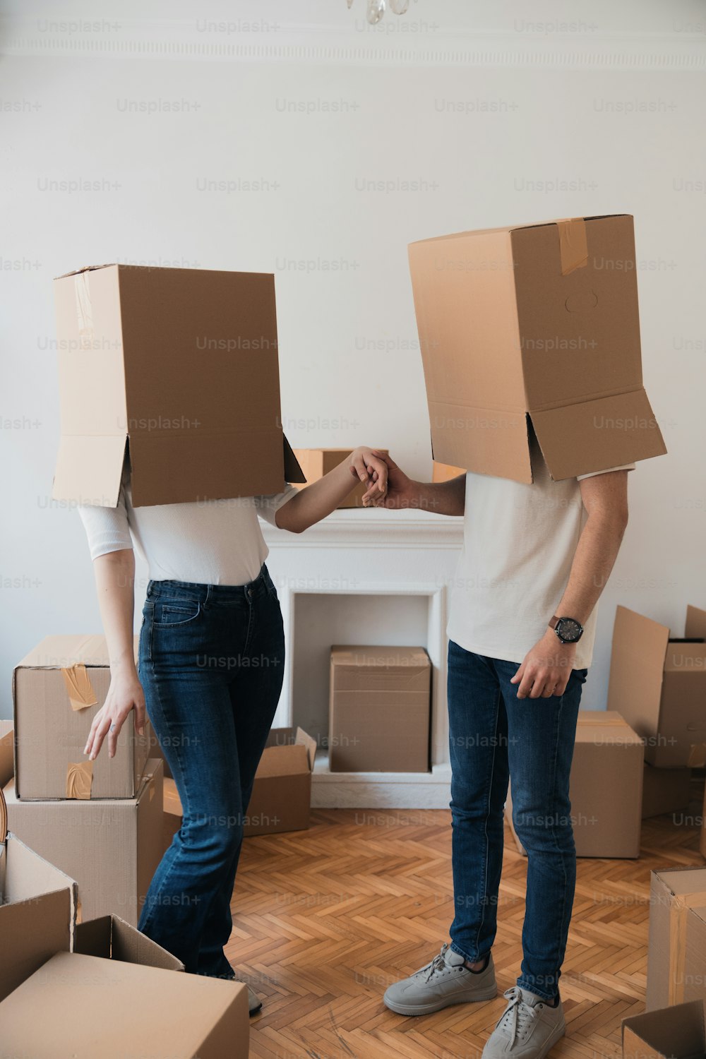 a man and a woman standing in a room with boxes on their heads