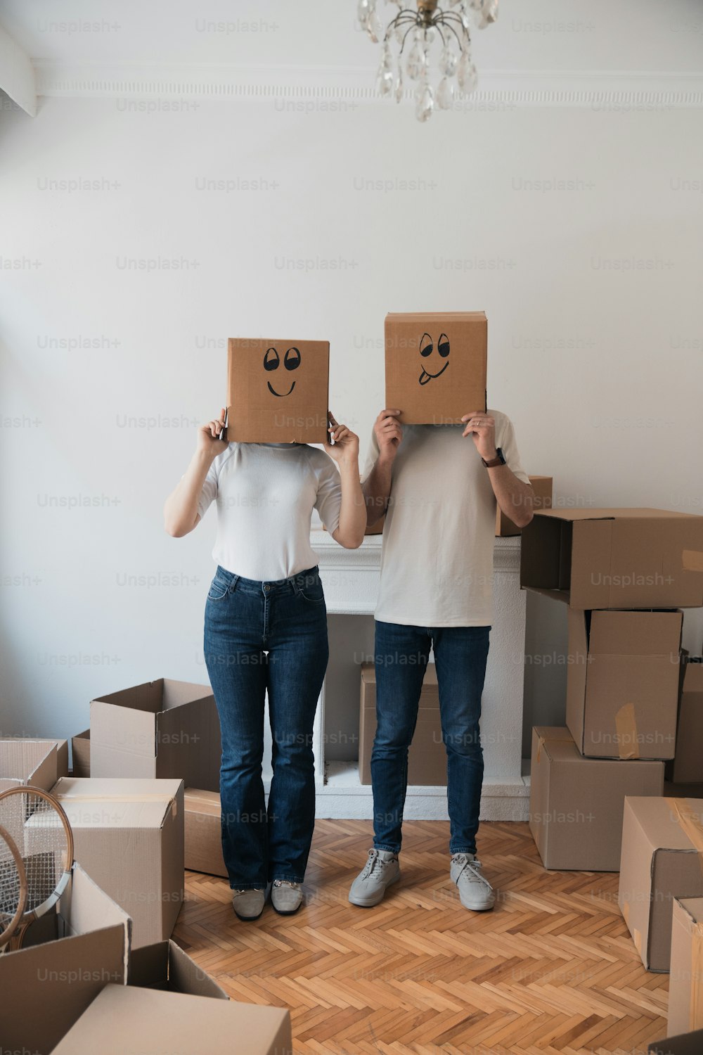 Dos personas sosteniendo cajas de cartón con caras dibujadas en ellas