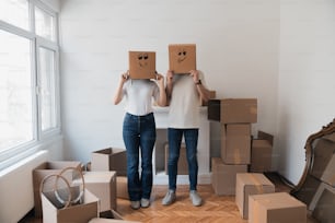 two people standing in a room with boxes on their heads