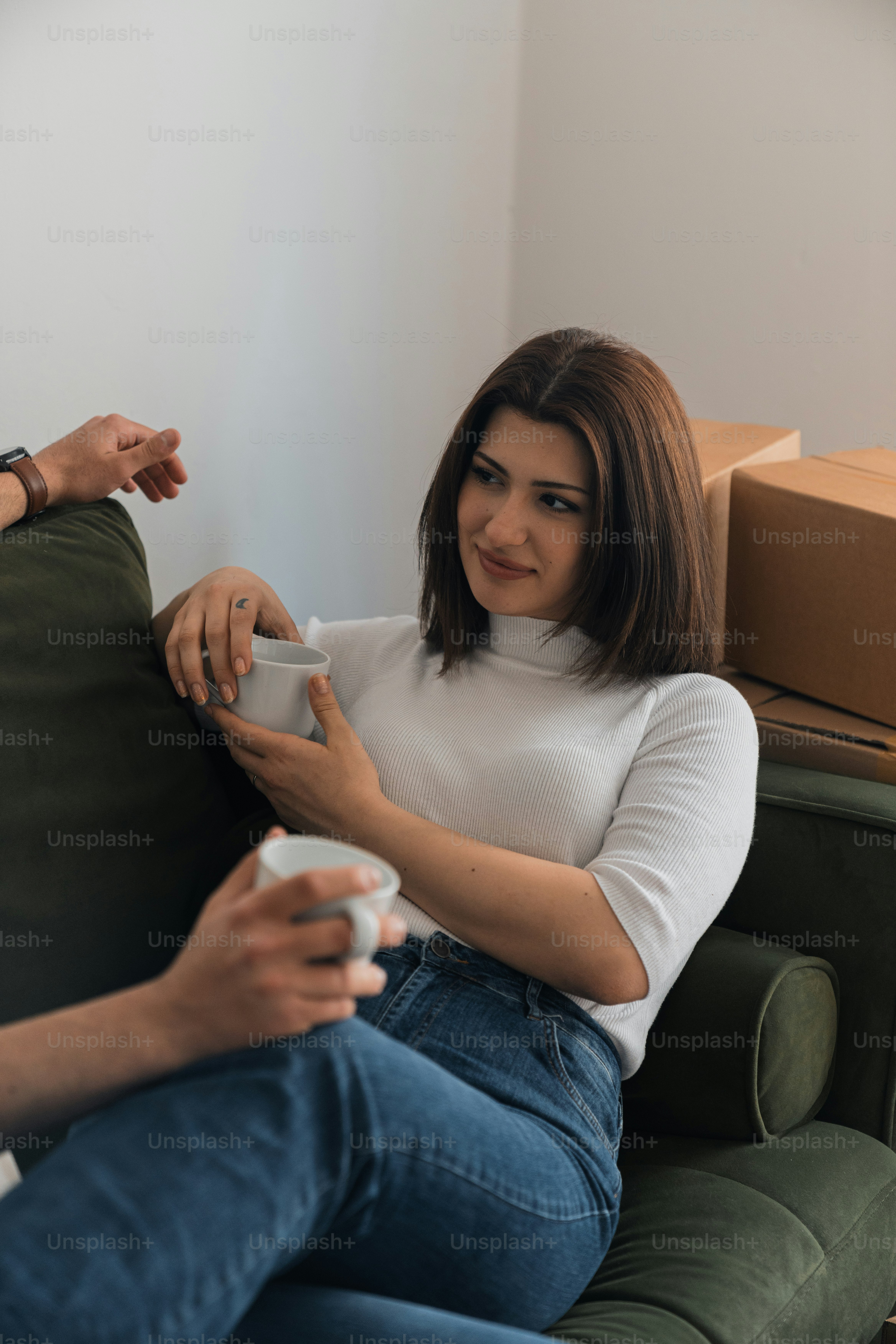 a woman sitting on a couch holding a remote control